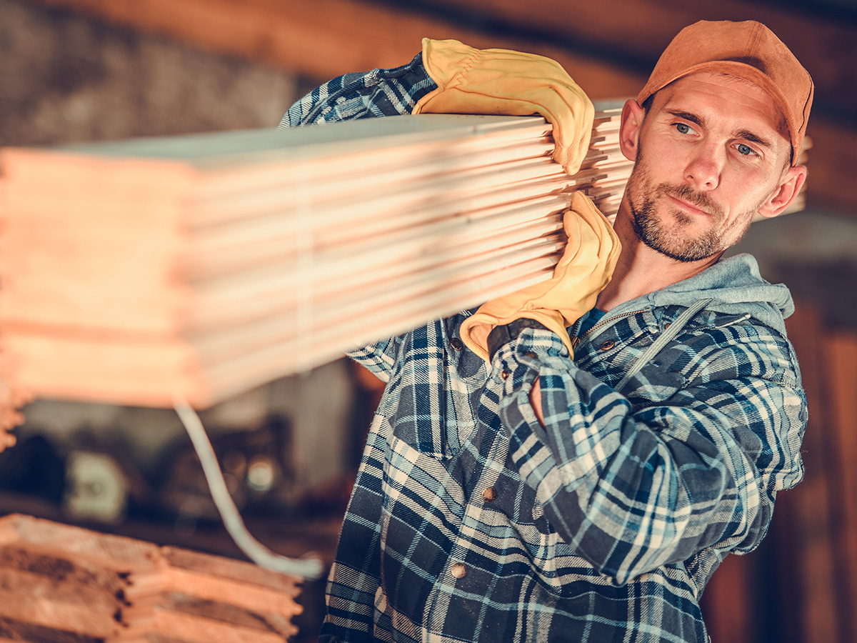 Lumber Contractor in His 30s with Wooden Planks on His Shoulder.