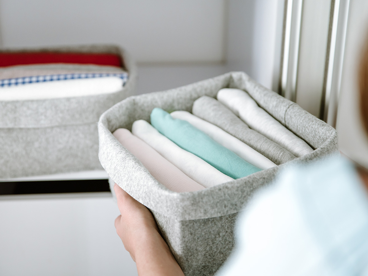 A woman organizing her closet using bins