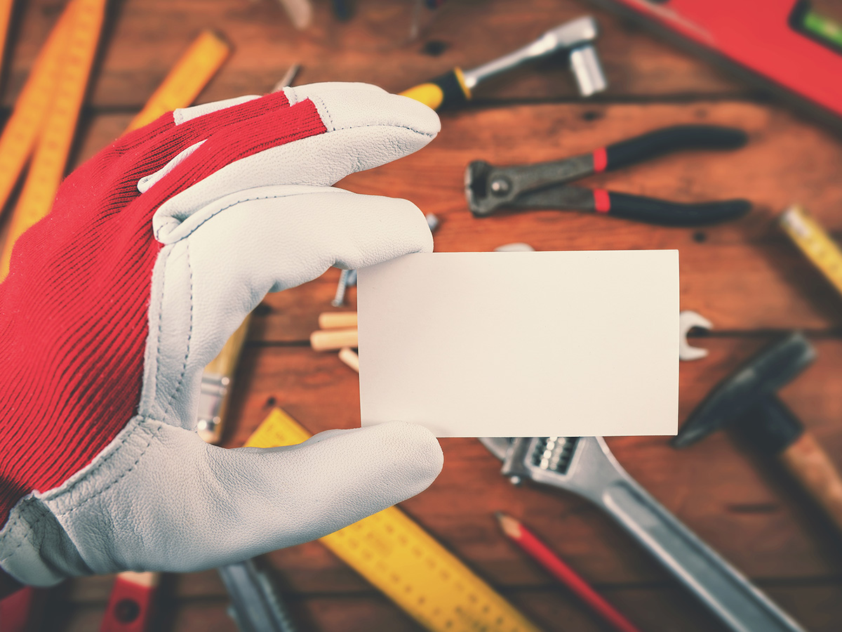 A gloved hand holding a blank tool label
